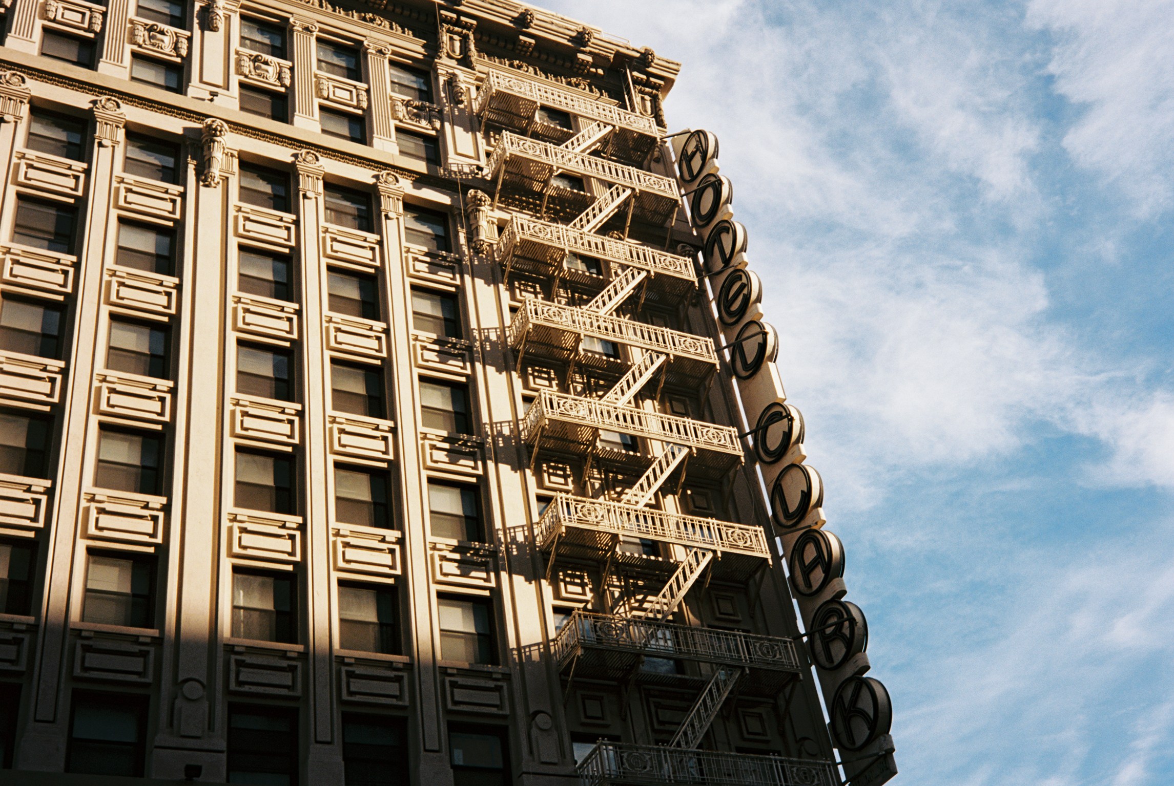 Historic Los Angeles building with external fire escapes against a blue sky.