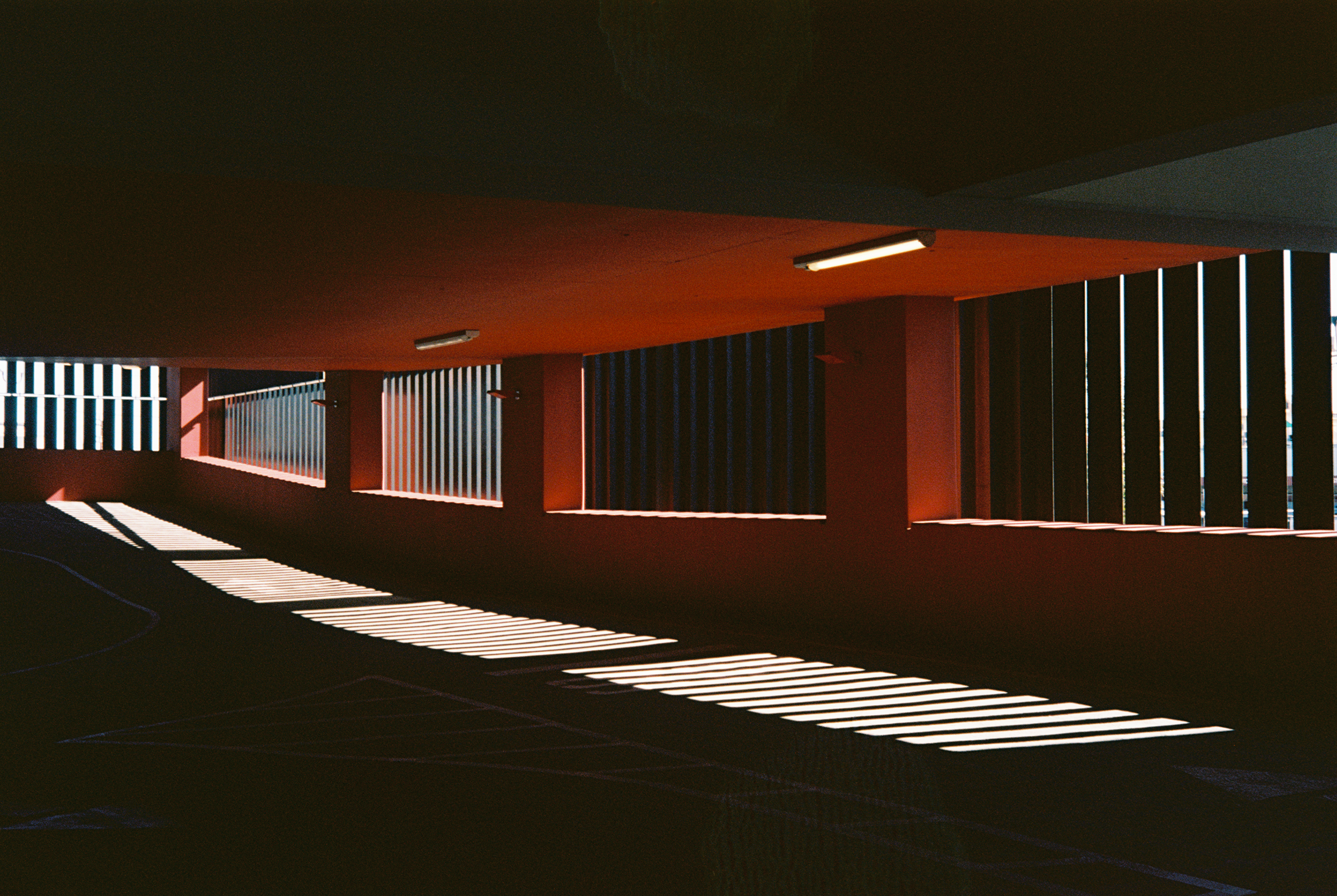 Sunlight forming repeating geometric patterns inside a parking structure.